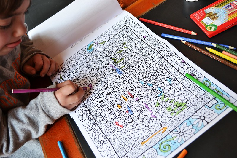 A child is drawing something on drawing book